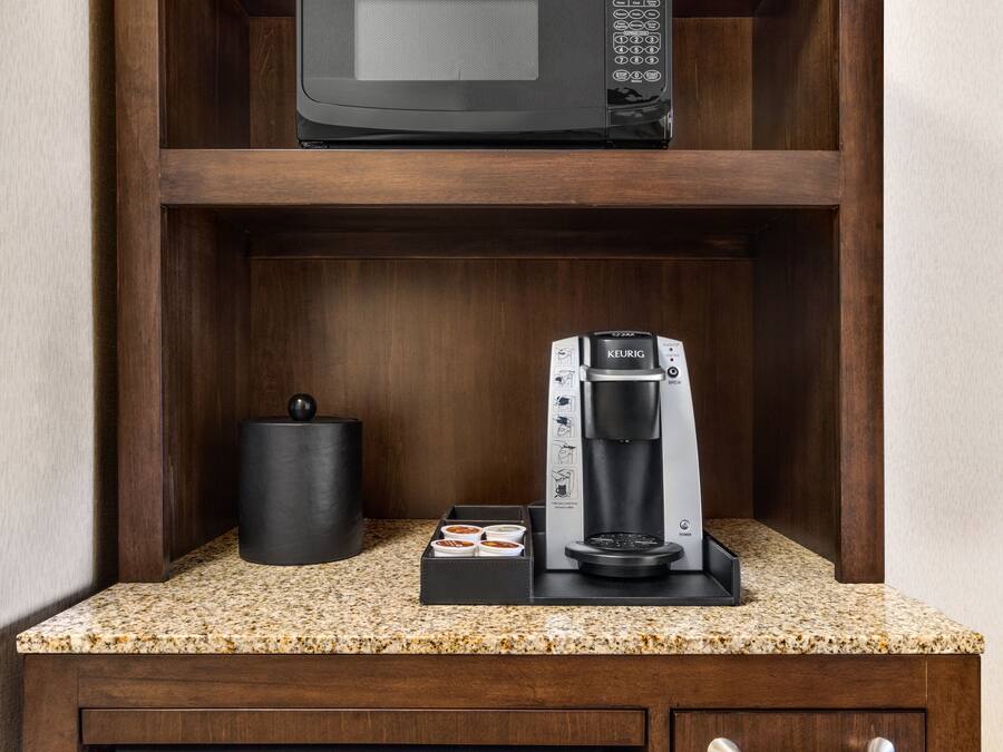 A kitchen with a microwave, coffee maker, and dishwasher.