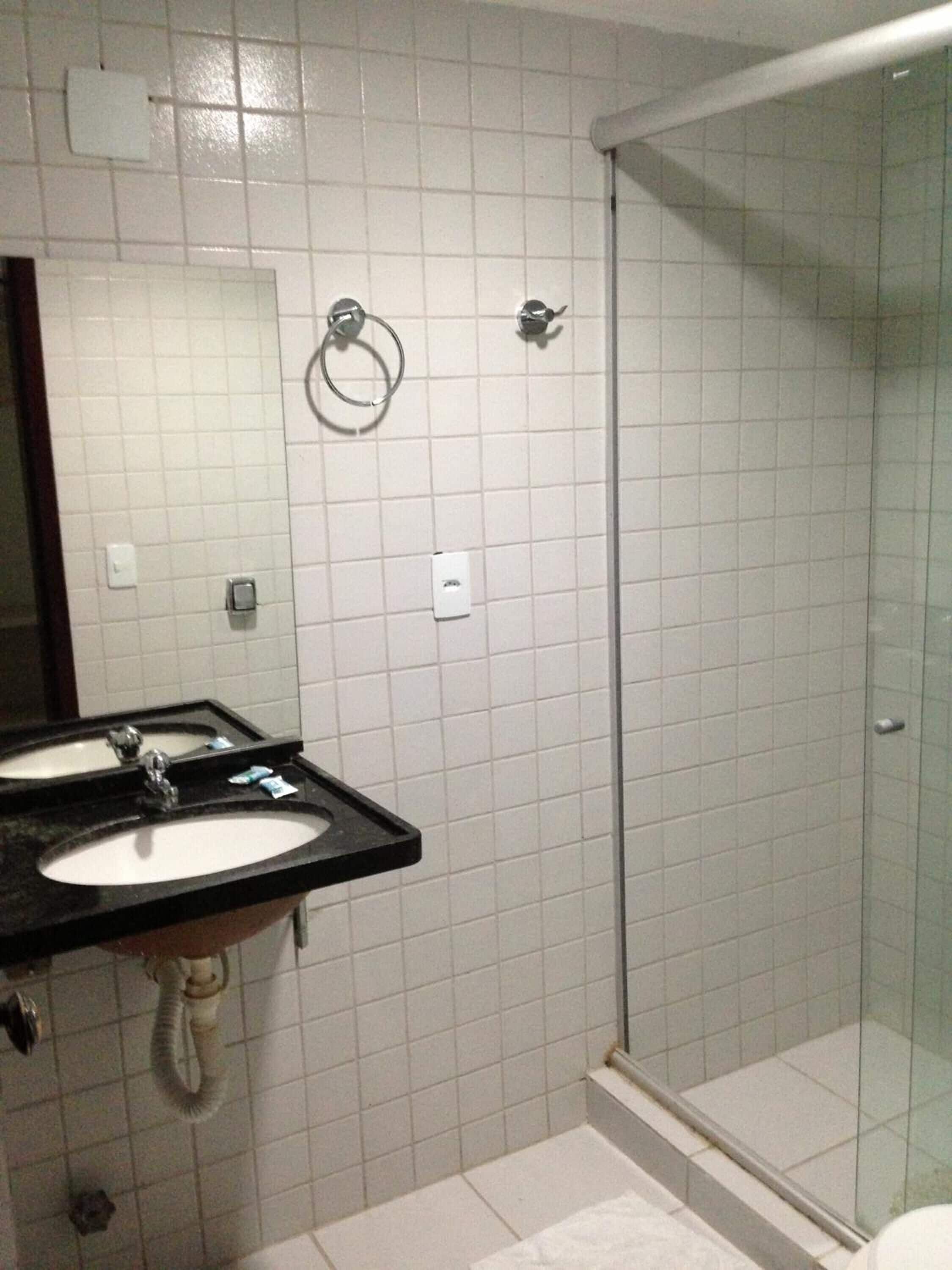 Ein Badezimmer mit zwei Waschbecken, einer Duschkabine aus Glas und einer Toilette.