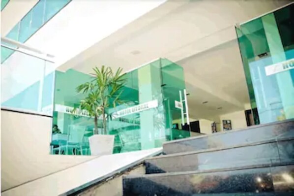 A modern building with glass walls, a staircase, and a potted plant. - Hotel Litoral Fortaleza (Fortaleza)