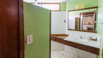 A bathroom with a wooden vanity, a white sink, and a mirror.