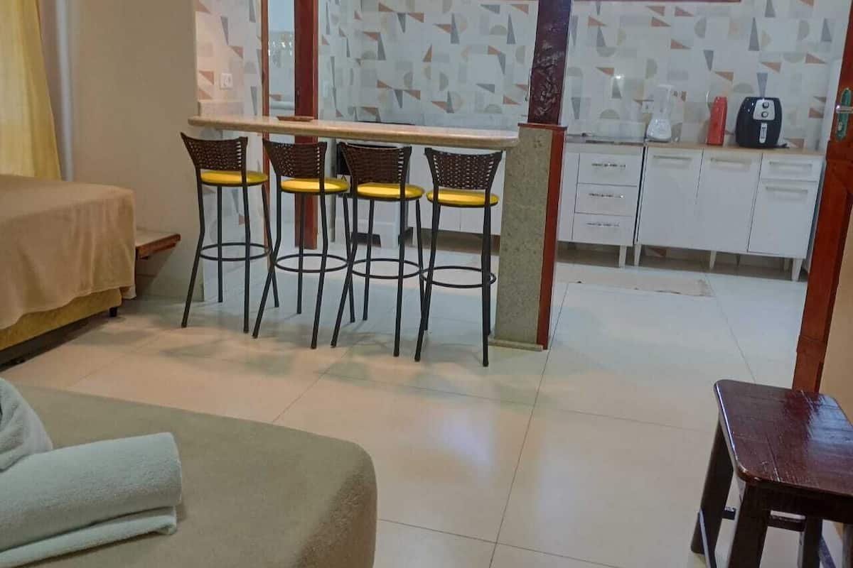 Ein Zimmer mit einem Bett, einer Schlafcouch, einem Essbereich mit Bar und einer Küchenzeile.