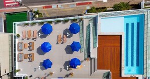 Una piscina al aire libre, sombrillas, sillones reclinables de piscina