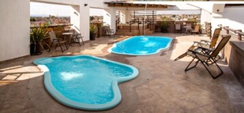 Una piscina al aire libre de temporada, sombrillas