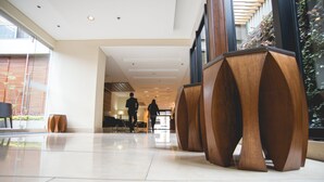 A modern lobby with a polished tile floor, wooden furniture, and large windows allowing natural light. - Mercure Bogotá Calle 100 (Bogotá)