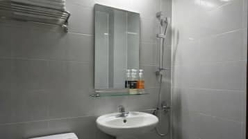 Uma casa de banho moderna com sanita, lavatório e chuveiro.