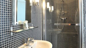 A bathroom with a sink, mirror, and shower. - Hôtel des Falaises (Etretat)