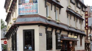 A historic building with a sign for "HOTEL DES FALAises" and a view of the sea. - Hôtel des Falaises (Etretat)