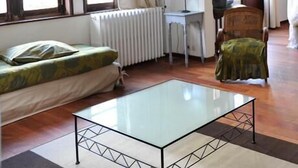 A room with a bed, a glass-top table, a desk, and a chair. - Hôtel La Résidence Manoir de La Salamandre (Etretat)