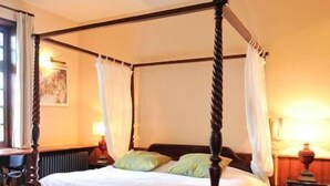 A four-poster canopy bed with a wooden frame and white bedding. - Hôtel La Résidence Manoir de La Salamandre (Etretat)