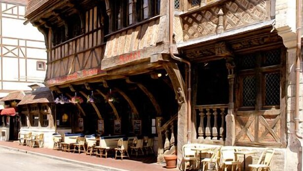 A traditional half-timbered building with a ground-floor café featuring outdoor seating. - Hôtel La Résidence Manoir de La Salamandre (Etretat)