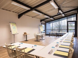 A conference room with long tables, chairs, and presentation boards.