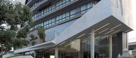 Un edificio moderno con un diseño angular distintivo, amplias ventanas y un área de entrada cubierta.