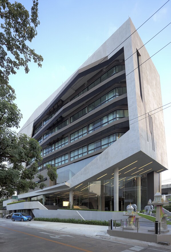Un bâtiment moderne au design original, caractérisé par des lignes angulaires, de grandes fenêtres et un espace d’entrée abrité.