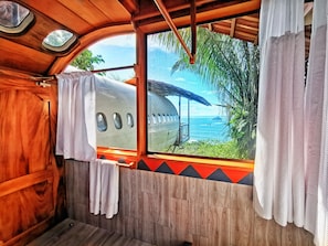 A wooden cabin with a view of a beach and a boat.