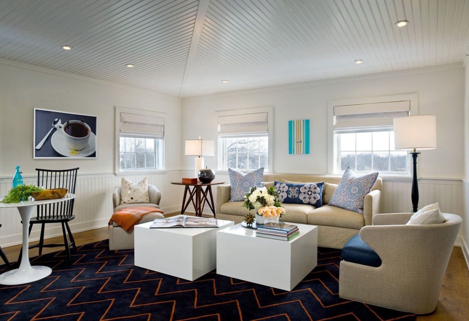 A modern living room with a sofa, two coffee tables, a chair, and a lamp.