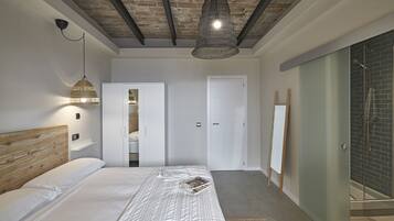 Een moderne slaapkamer met een houten hoofdbord, een bed met een beddengoed met patroon, een hanglamp, een inloopkast met schuifdeuren, en een douchecel met een glazen deur.