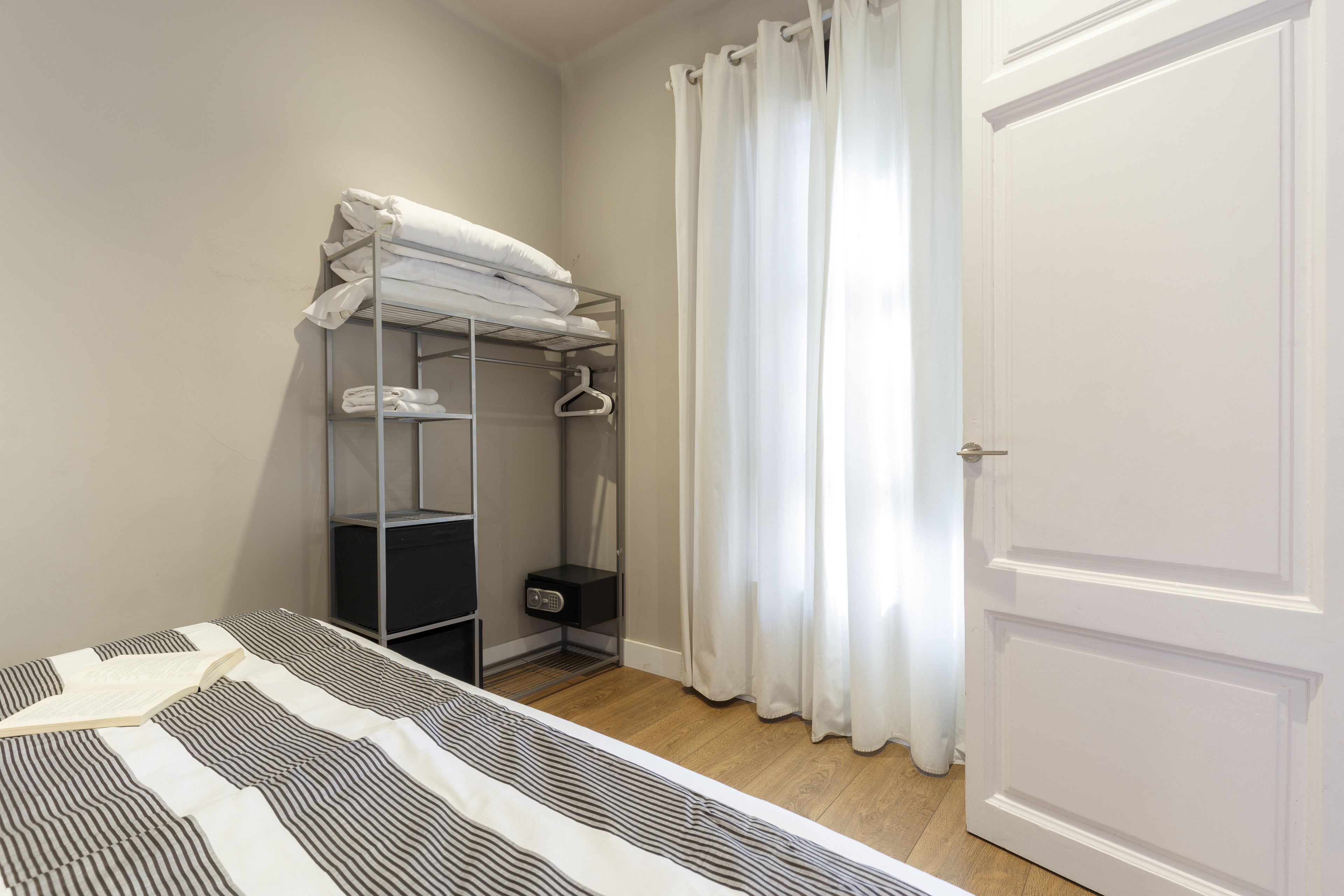 A bedroom with a bunk bed, a wardrobe, and a door.
