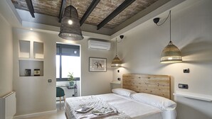 Un dormitorio moderno con una cama grande, luces colgantes y vistas al exterior.