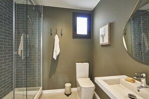A bathroom with a glass-enclosed shower, a toilet, and a sink with a mirror. - AinB Eixample Miró Apartments (Barcelona)