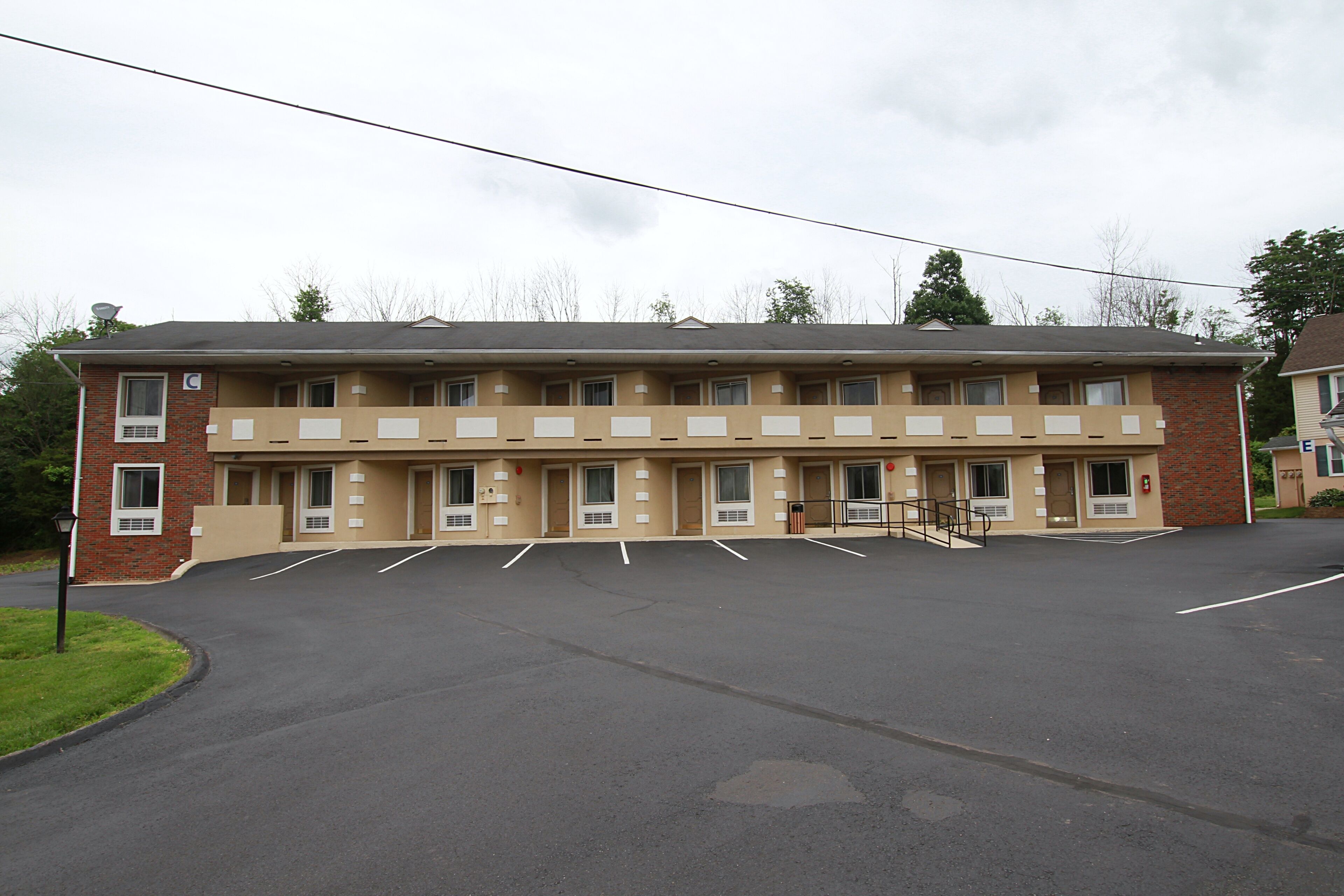 Um motel com estacionamento central e vários quartos.