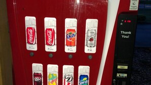 A Coca-Cola vending machine with various drink options and a calorie count display. - Motor Inns Of America (Madisonville)