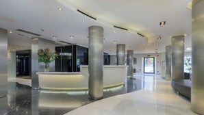 A modern lobby with a reception desk, large pillars, and a clean, polished floor. - Hotel Ciutadella Barcelona (Barcelona)