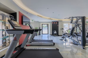 A modern gym with treadmills, a weight machine, and a large mirror.