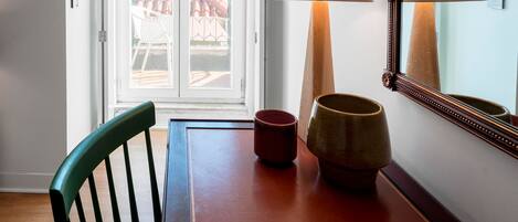 Una mesa de madera con una silla, una lámpara y una taza.