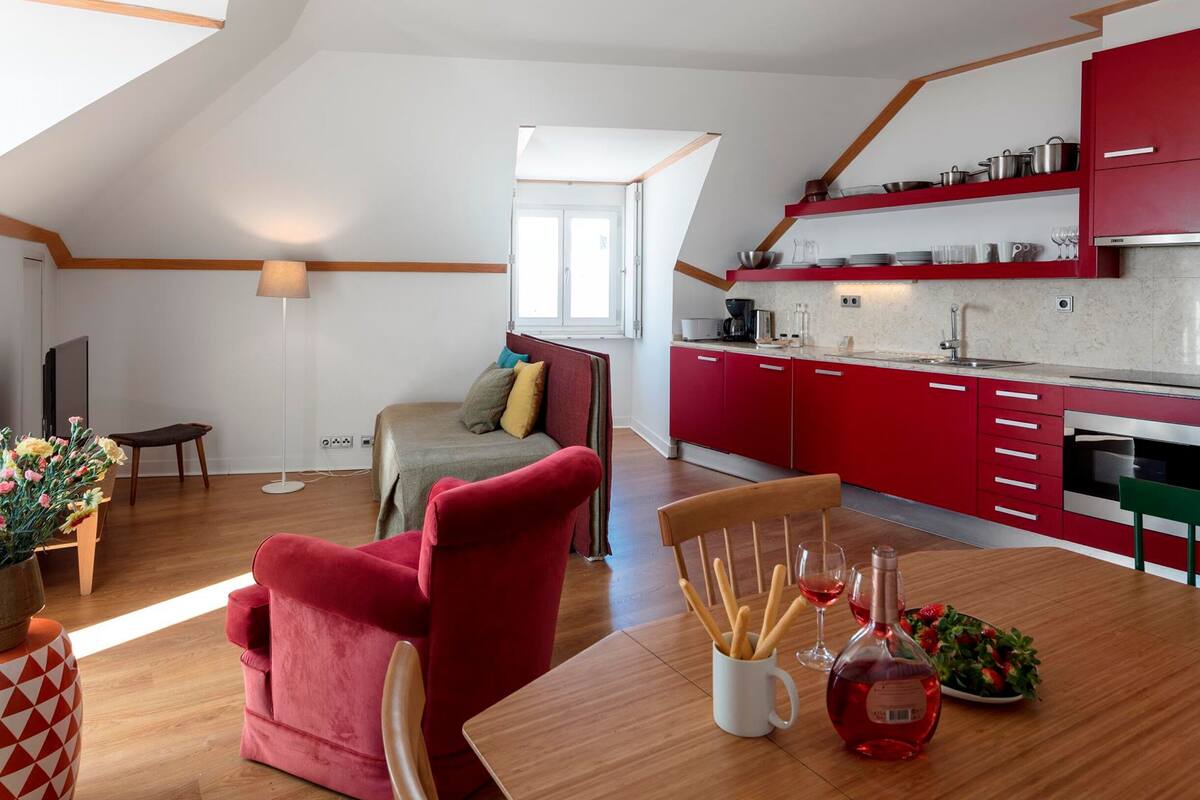 A modern loft apartment with a dining area, kitchen, and a cozy seating space.