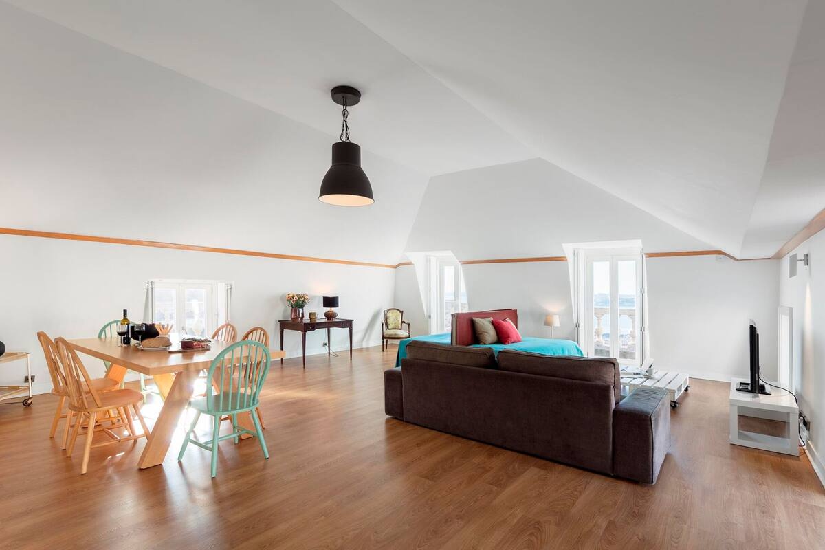 A spacious loft with a dining area, a sofa, and a bed.