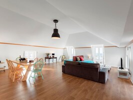 Um loft espaçoso com área de jantar, sofá e cama.