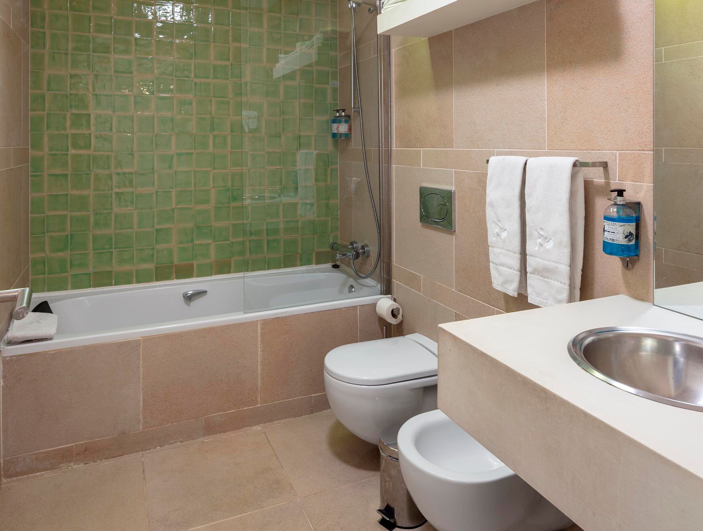 Een badkamer met een bad, toilet en wastafel.