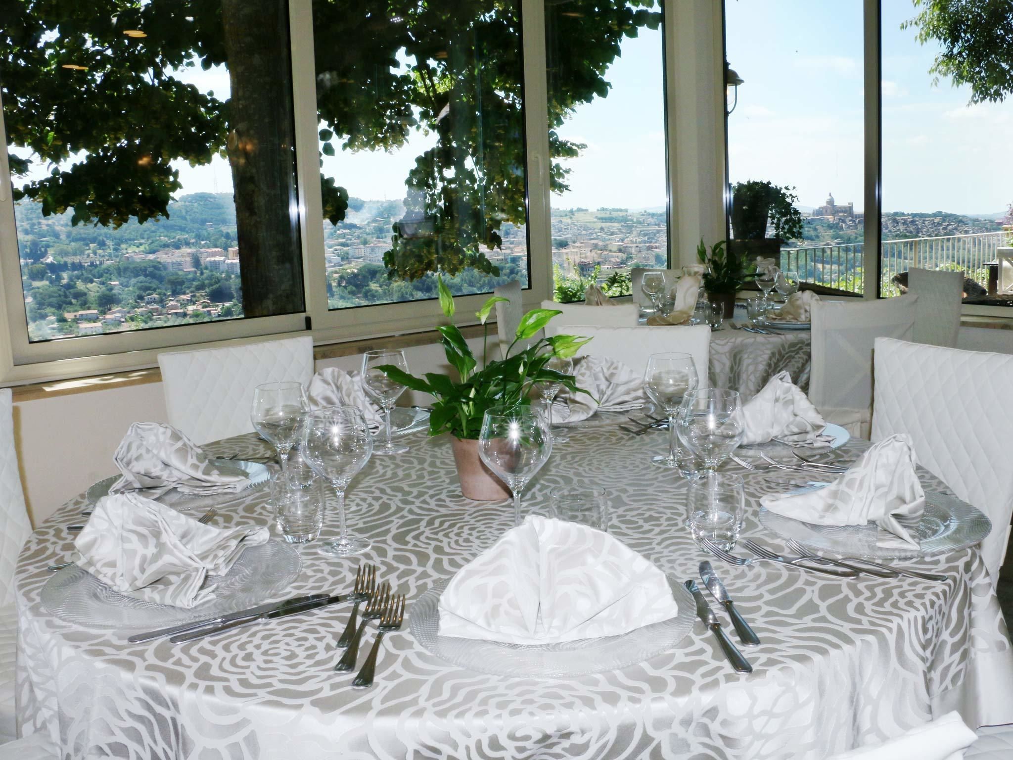 A dining table set for six with a view of a cityscape through large windows.
