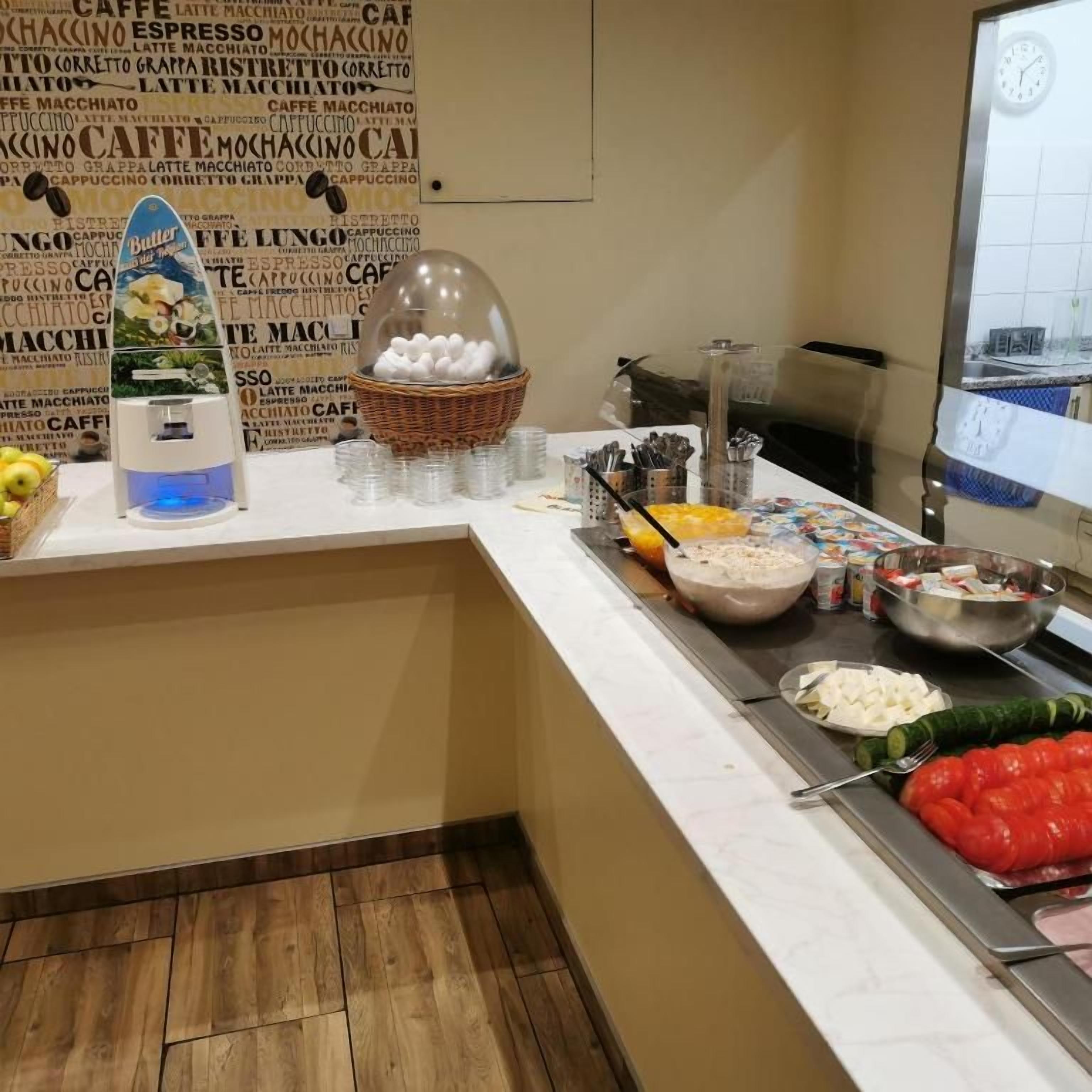 A buffet counter with various food items and a coffee station.