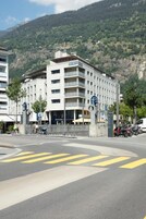 Un hotel de varios pisos con un patio central, rodeado por un paisaje montañoso.