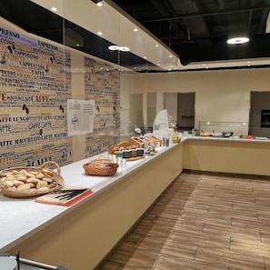 A café counter with a variety of coffee and pastry options, a menu board, and a clean, modern interior.