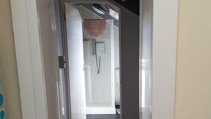 A hallway leading to a bathroom with a shower, a towel rack, and a ceiling with a starry design. - Trentham Private Hotel (Blackpool)