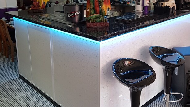 A bar area with a dragon statue, a Carling branded machine, and a blue-lit counter. - Trentham Private Hotel (Blackpool)