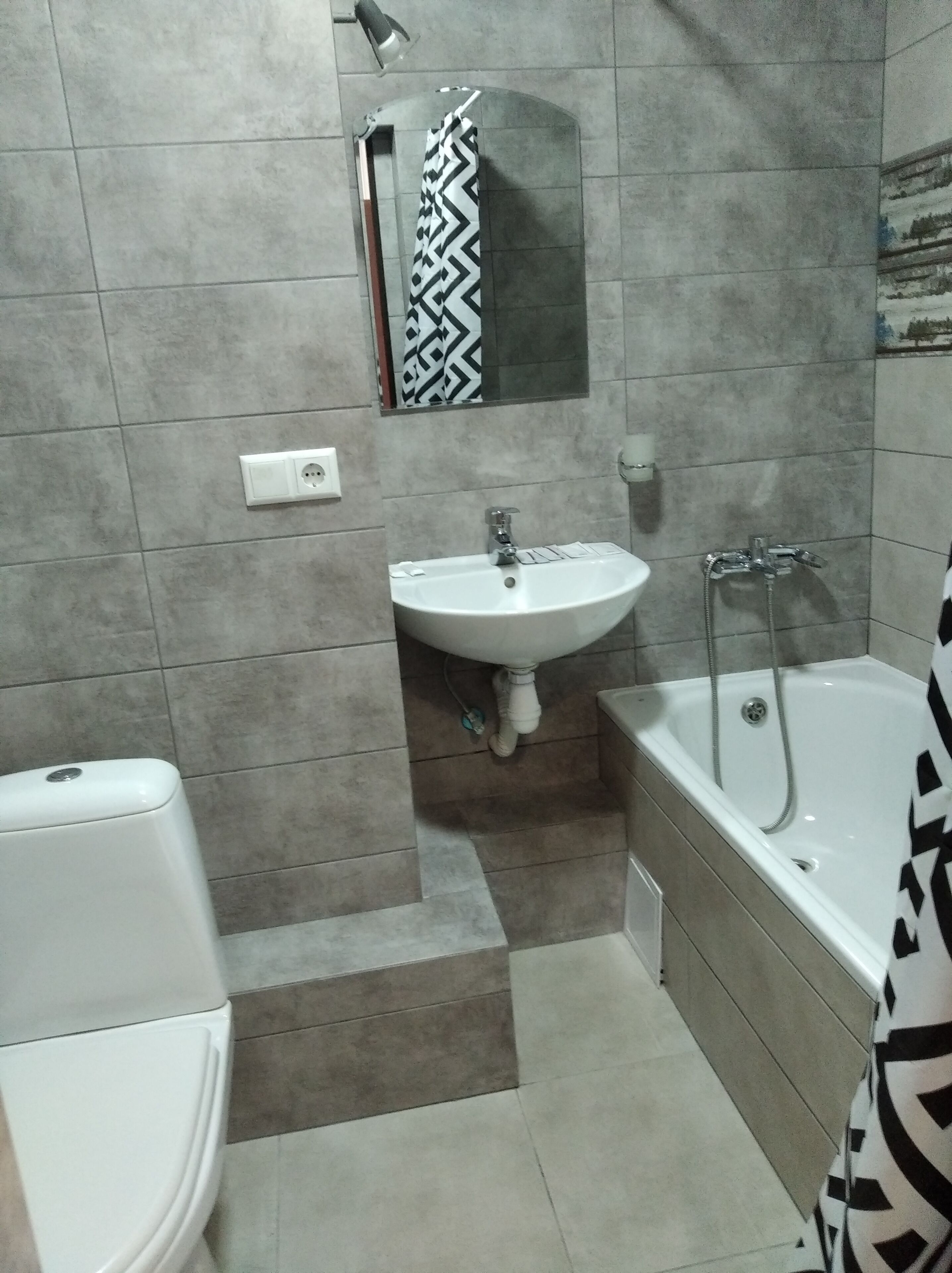 A bathroom with a white sink, a toilet, and a bathtub.