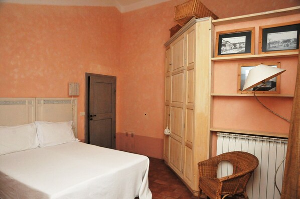 Un dormitorio con cama, armario y una silla.