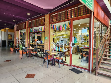A café with outdoor seating, a staircase, and a visible menu board.. Park Place Hotel