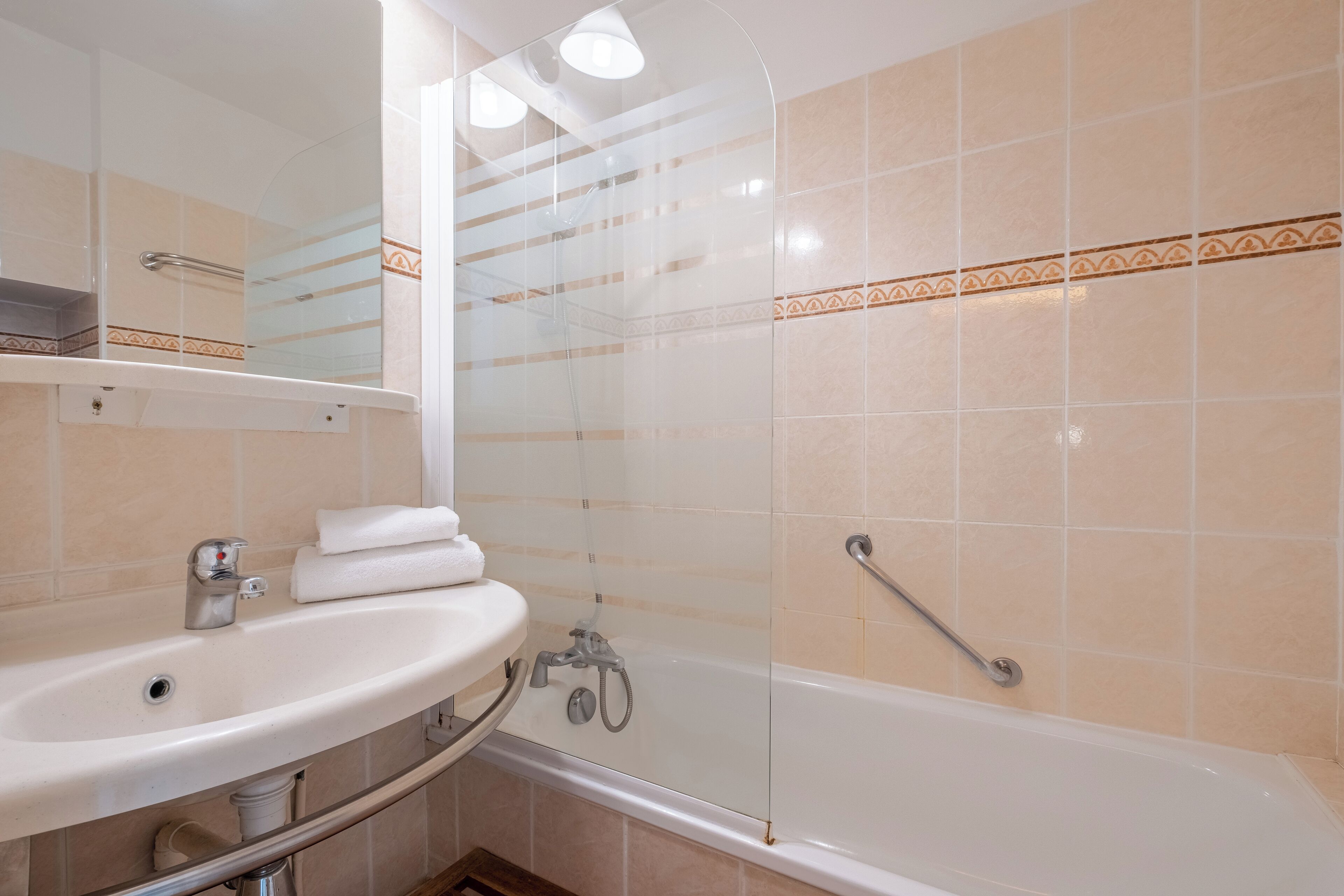 Un baño con lavamanos, espejo y bañera.