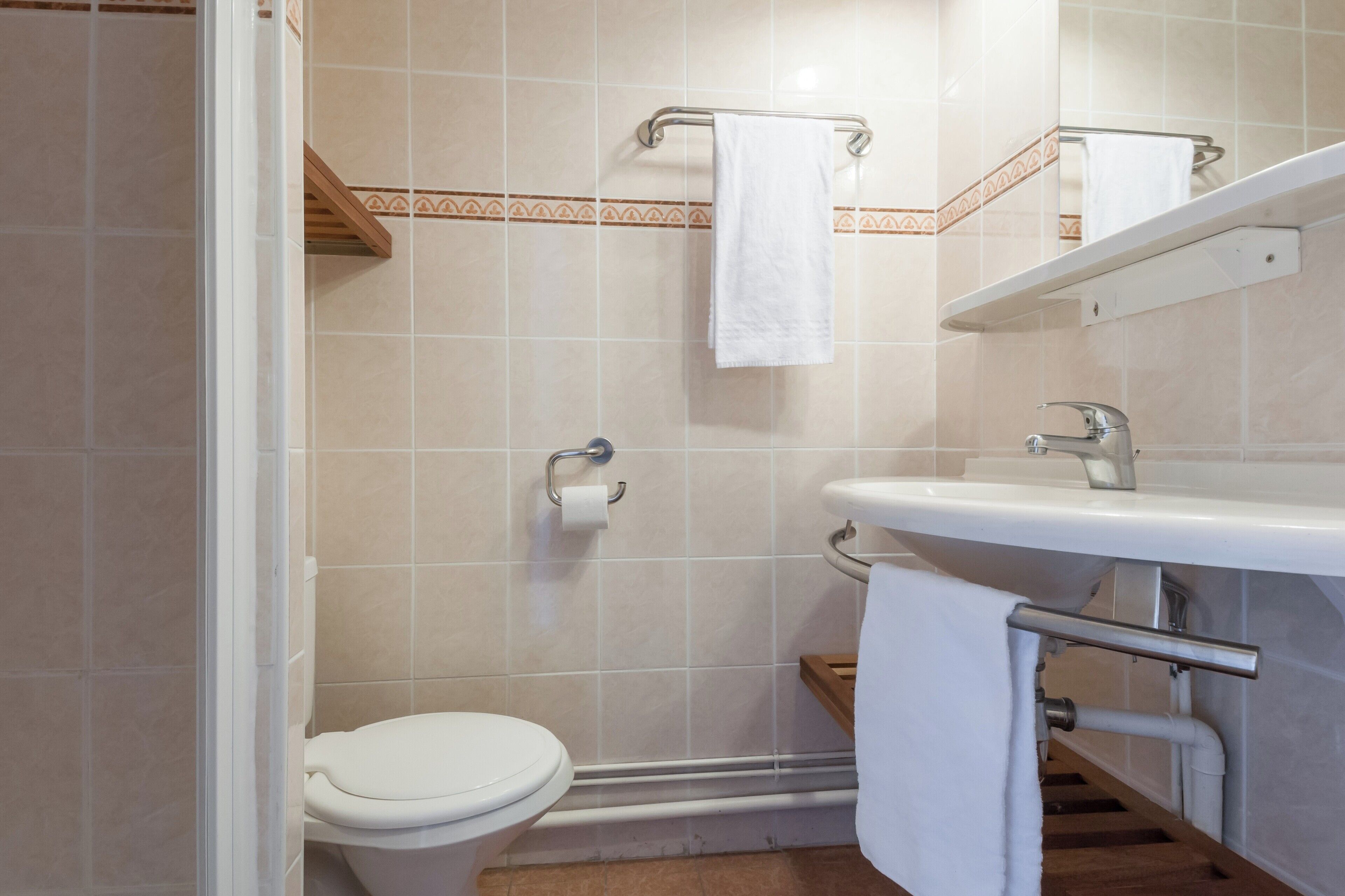 Een badkamer met toilet, wastafel en douche.