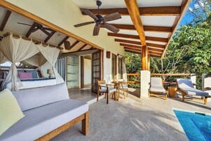 Un espacio exterior cubierto con piscina, sofá, sillas y ventilador de techo.