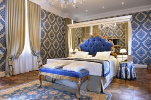 Un dormitorio lujoso con una cama grande, un cabecero ornamentado y un banco a juego.