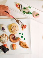 Une variété de plats de fruits de mer présentés sur une assiette blanche.