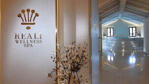 Un espace d’accueil avec une enseigne indiquant « REALI WELLNESS SPA » et une plante décorative.