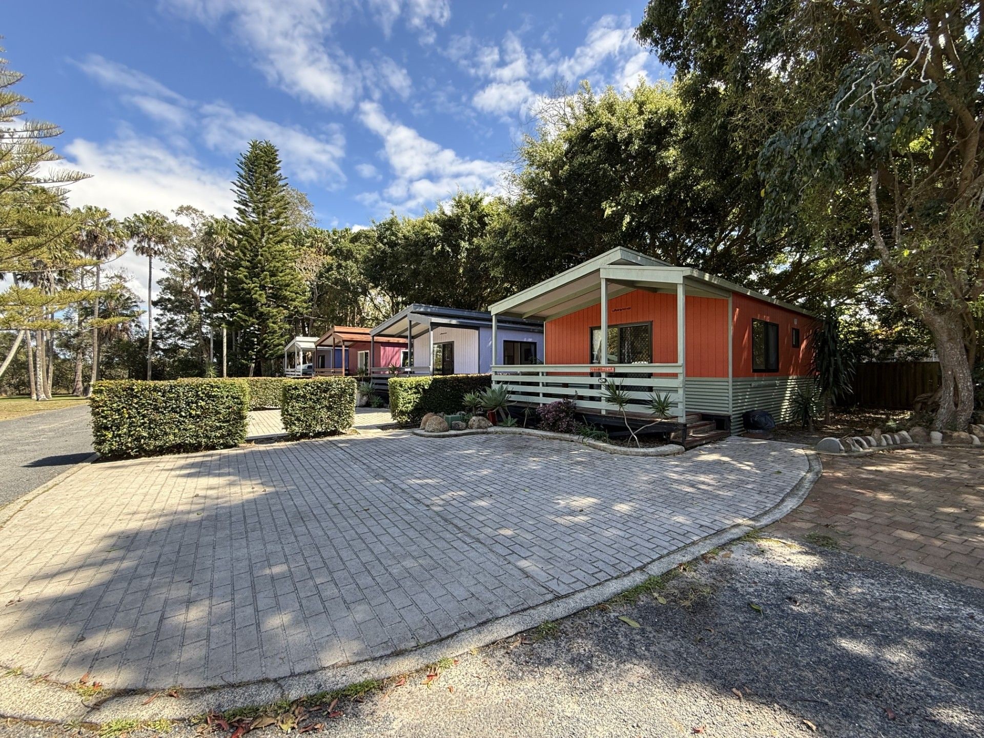 A residential area with a paved driveway leading to a row of houses.