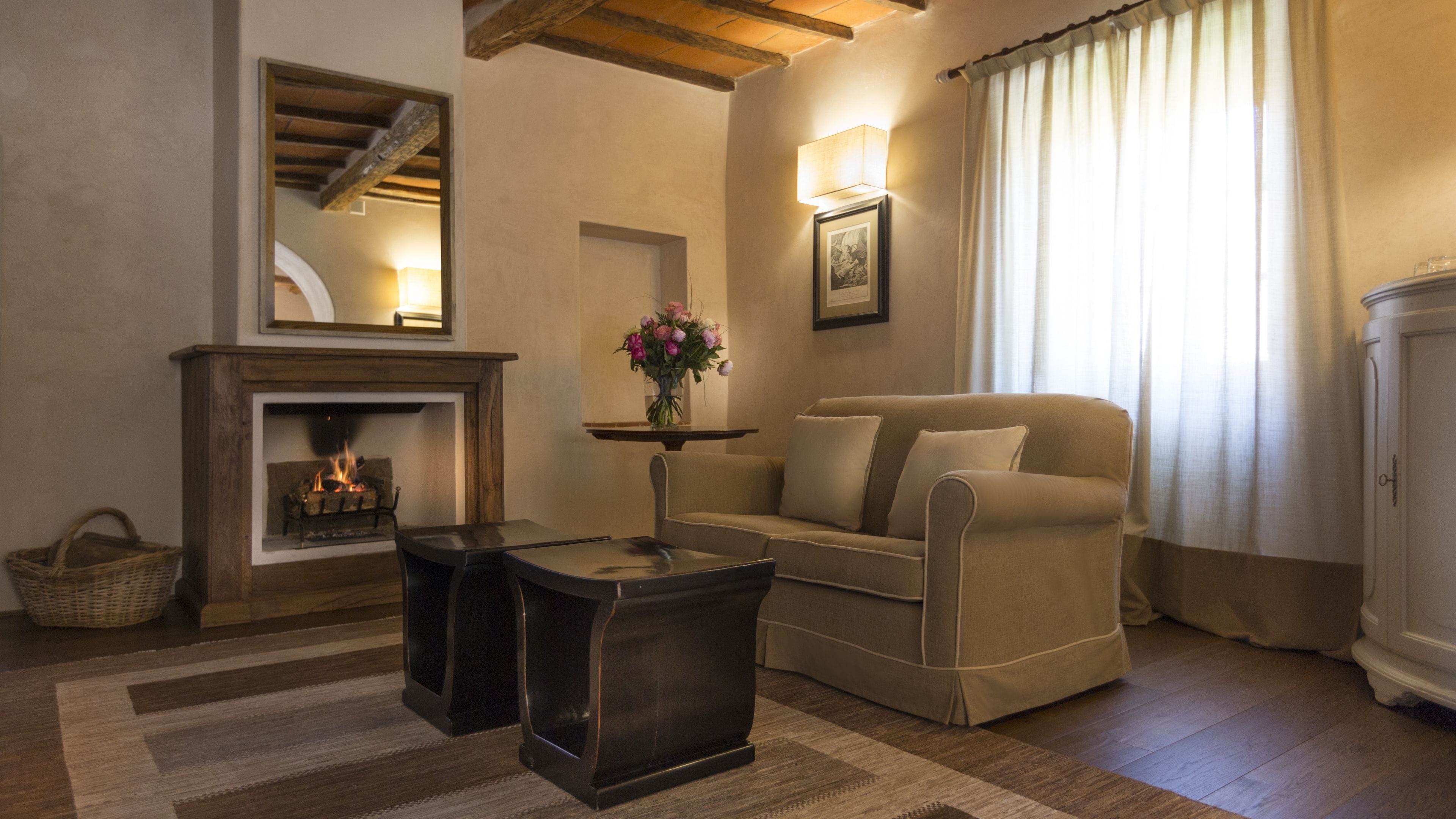 Un salon chaleureux avec une cheminée, un canapé, une petite table et une lampe.
