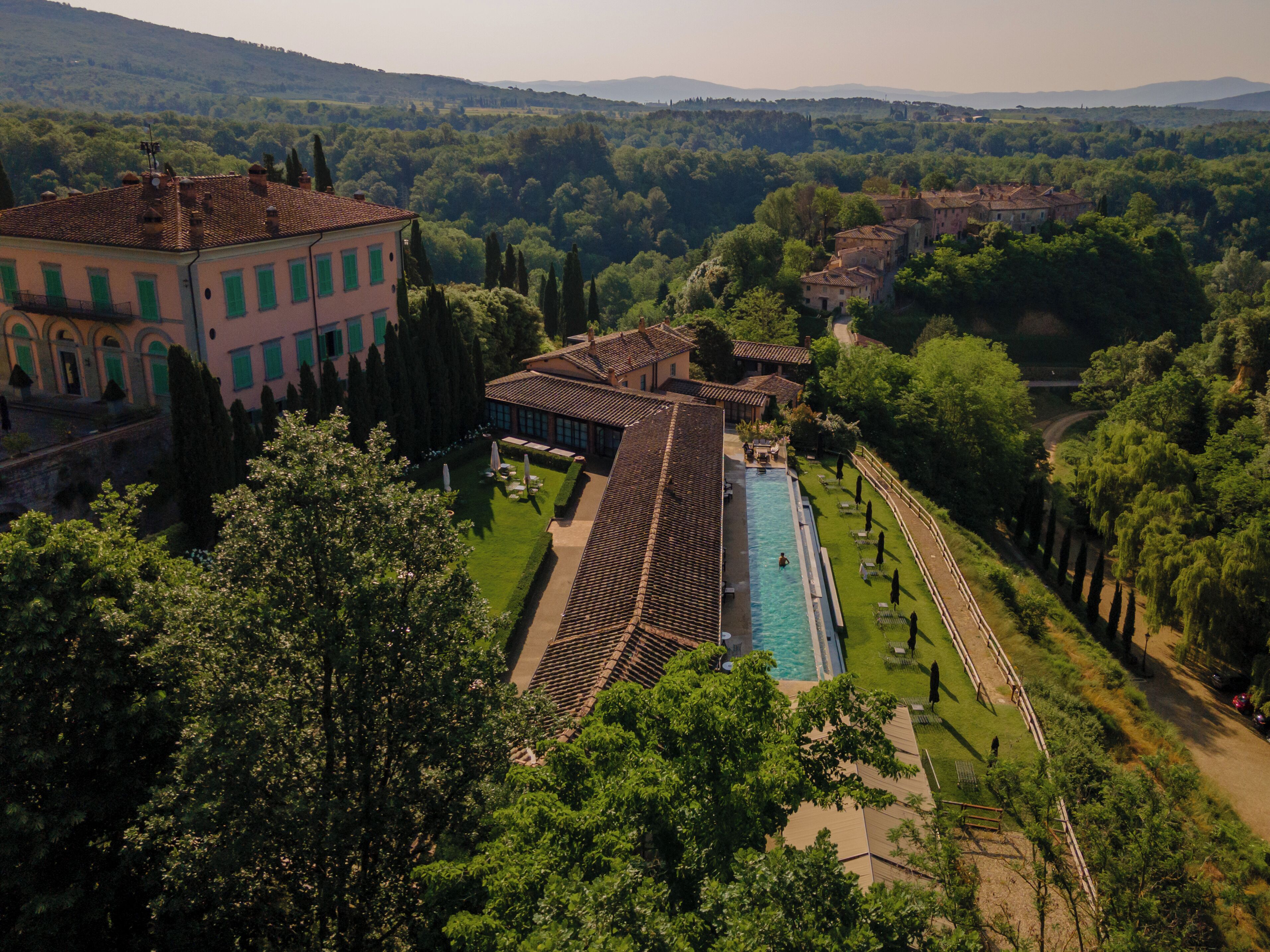 Ein weitläufiges Anwesen mit Swimmingpool, gepflegten Gärten und mehreren Gebäuden mit Terrakotta-Dachziegeln.